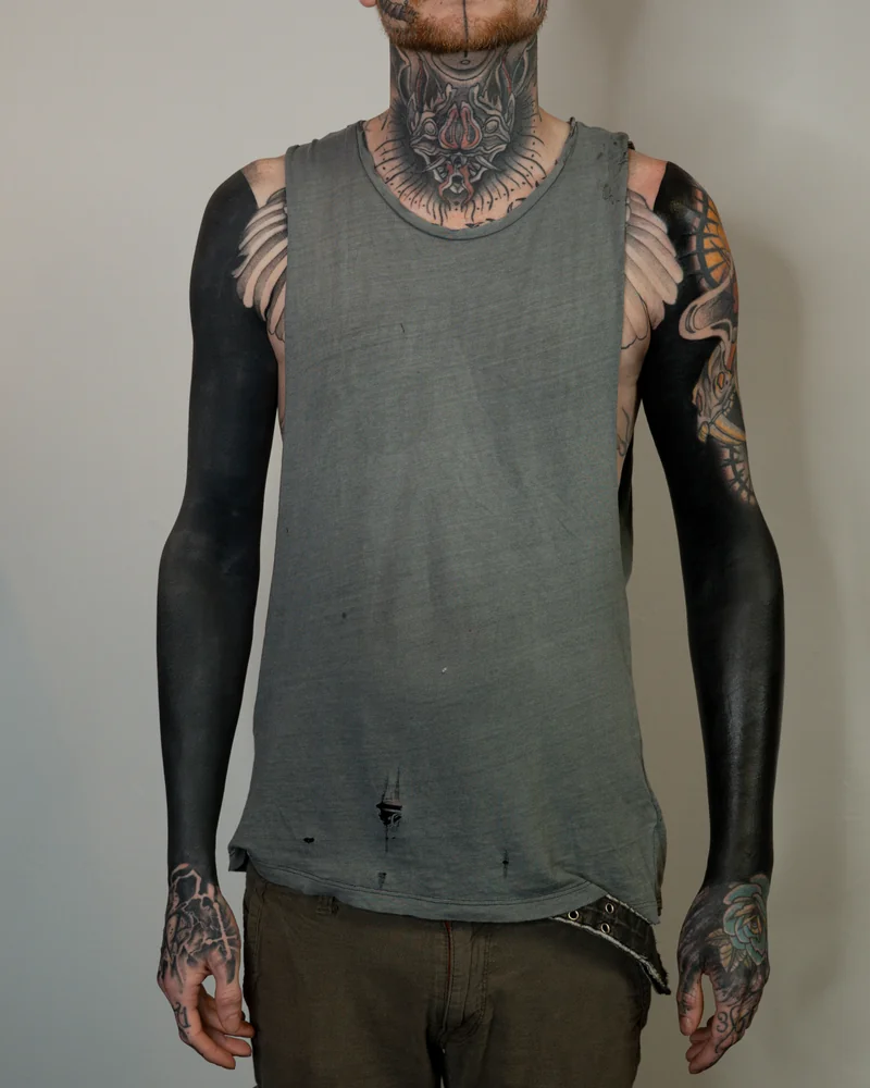 Großflächige schwarze Tattoos an beiden Armen
