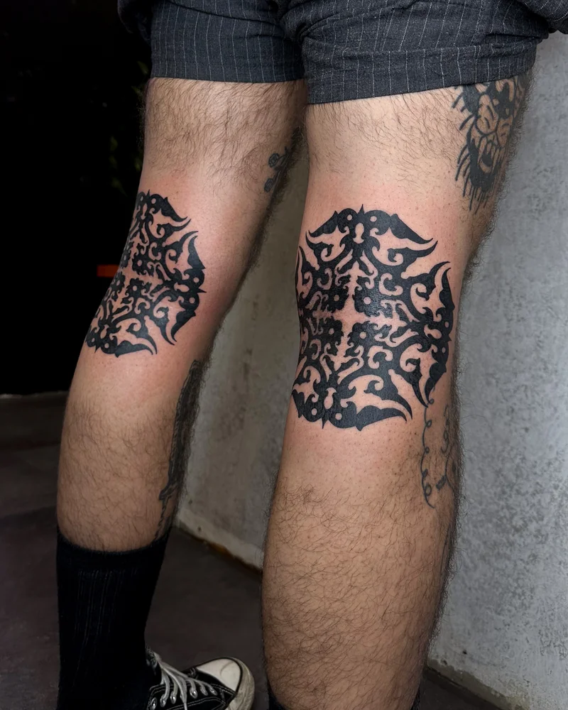 Borneo-inspirierte schwarze Ornamente an beiden Knien