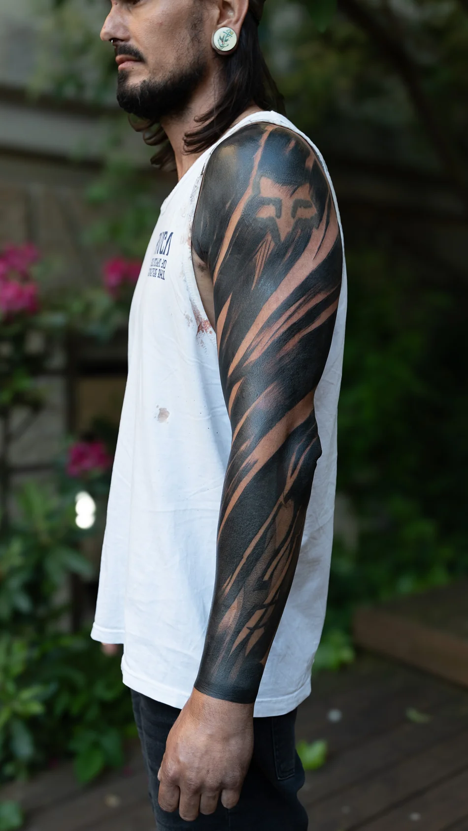 Frisch gestochen: Blackwork-Cover-up über den gesamten Arm mit großen schwarzen Formen und offenen Hautlinien