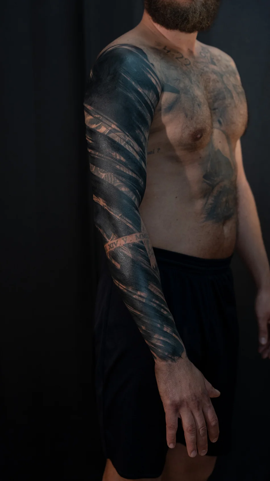 Frisch gestochen: Abstraktes Freehand-Cover-up am Arm mit schwarzen Pinselstrichformen, Seitenansicht