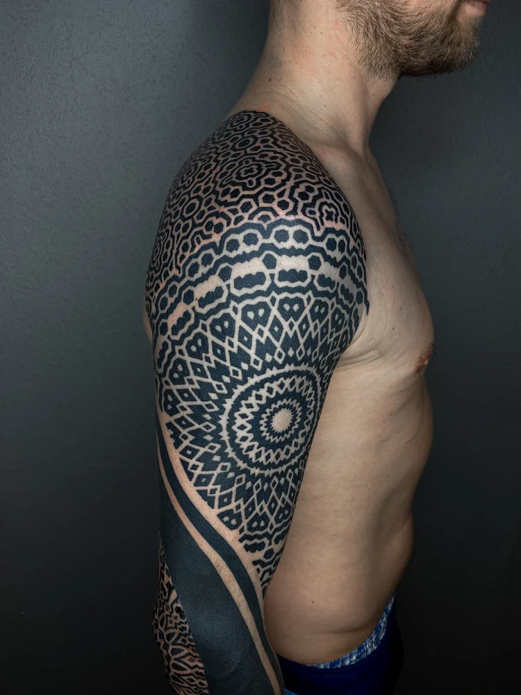 Abgeheilt: Geometrisches Tattoo an Schulter und Oberarm mit Mandala, Rauten und wiederholten Ornamenten