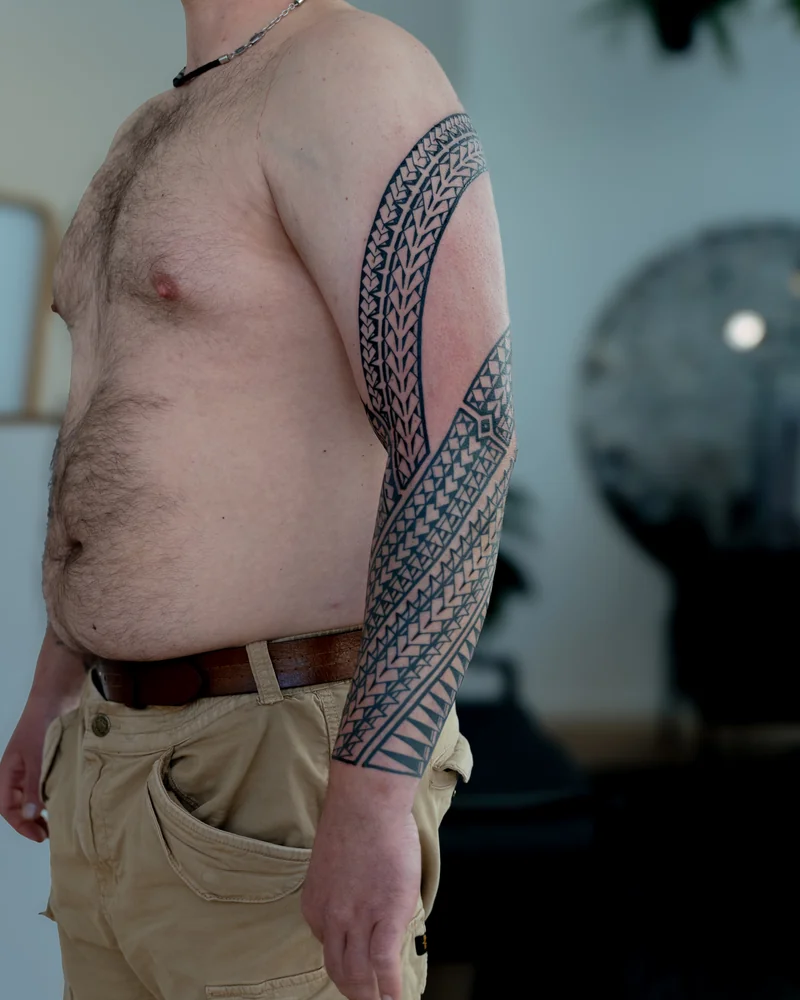 Abgeheilter samoanisch inspirierter Freehand-Sleeve mit diagonalen Musterbändern von Schulter bis Handgelenk
