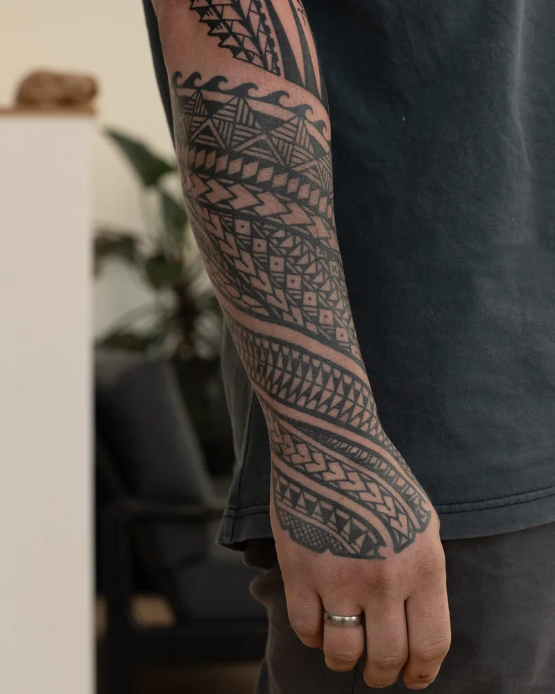 Abgeheiltes samoanisch inspiriertes Unterarmtattoo mit diagonalen Musterbändern, freehand ohne Schablone entworfen