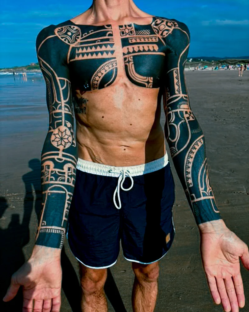 Abgeheilt: Marquesas-inspirierte Tattoos auf Brust und Armen mit breiten schwarzen Flächen und figürlichen Motiven