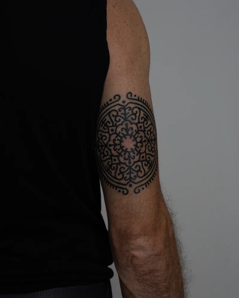Rundes ornamentales Medaillon aus schwarzen Linien am Arm