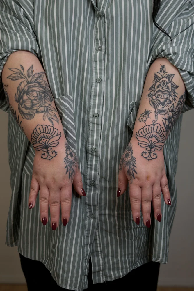 Passende ornamentale Blütenmotive an beiden Handgelenken zwischen bestehenden Tattoos