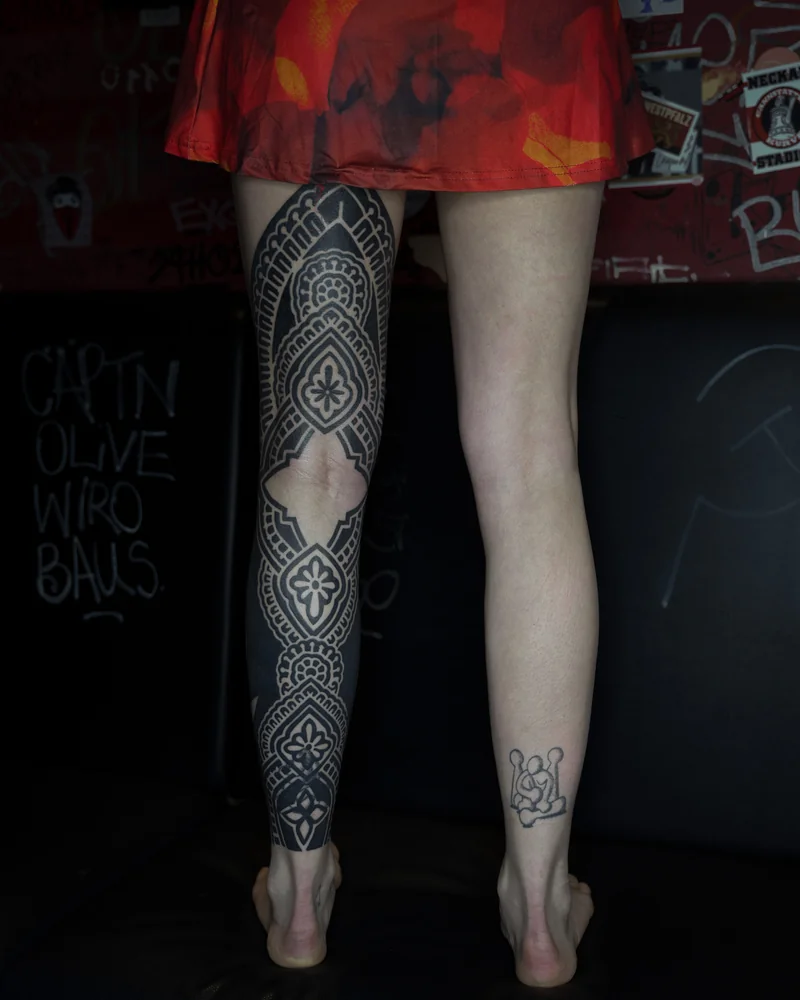 Abgeheiltes ornamentales Cover-up und Blast-over am Bein mit floralen Motiven und schwarzen Flächen – Gesamtansicht von hinten