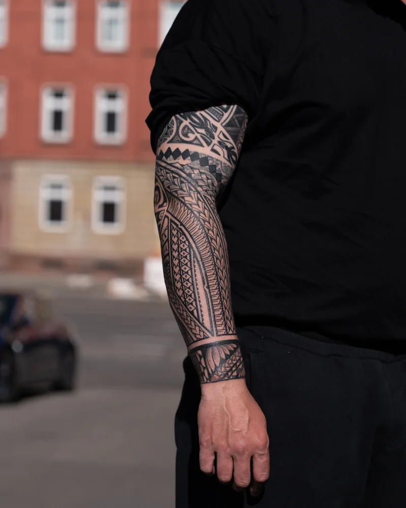Samoanisch inspiriertes Freehand-Cover-up am Arm mit geometrischen Musterbändern