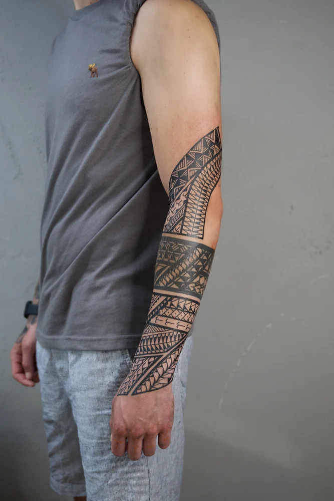Samoanisch inspirierte Musterbänder am Arm mit Dreiecken und schwarzen Flächen